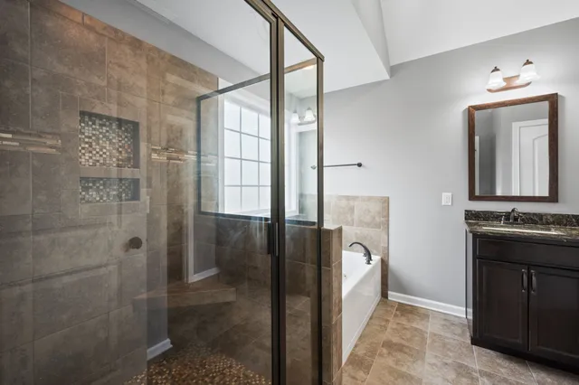 a spacious bathroom with a mirror a bathtub and shower