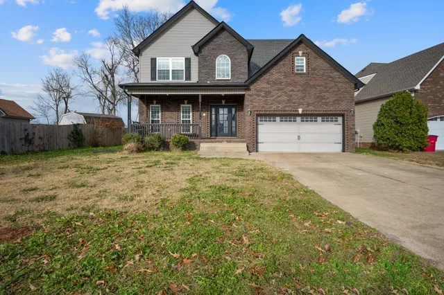 a front view of a house with a garden and yard