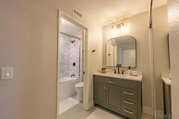 a bathroom with a double vanity sink toilet mirror and bathtub