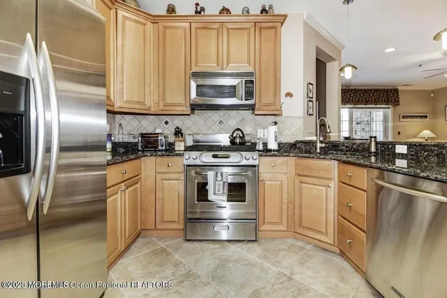a kitchen with stainless steel appliances granite countertop a stove a sink and a refrigerator