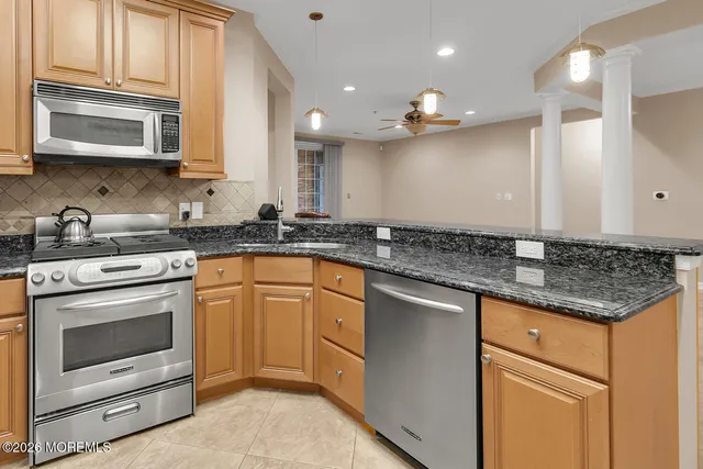 a kitchen with stainless steel appliances granite countertop a stove a sink and a microwave