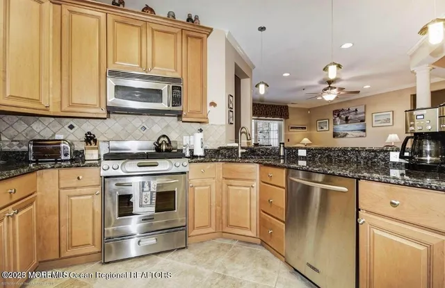 a kitchen with stainless steel appliances granite countertop a stove a sink and a microwave