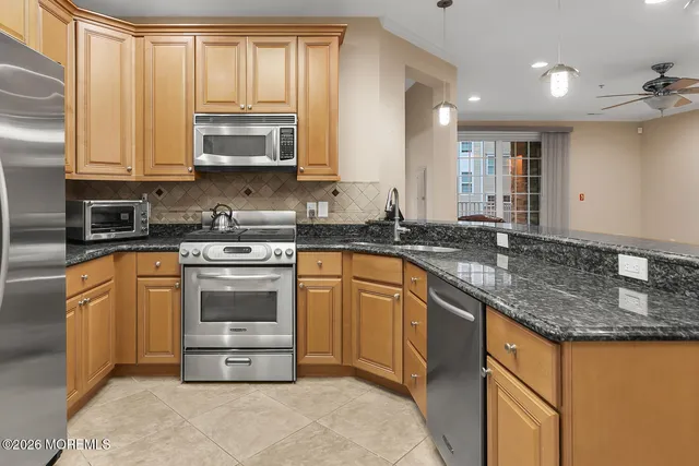 a kitchen with stainless steel appliances granite countertop a stove a sink and a refrigerator