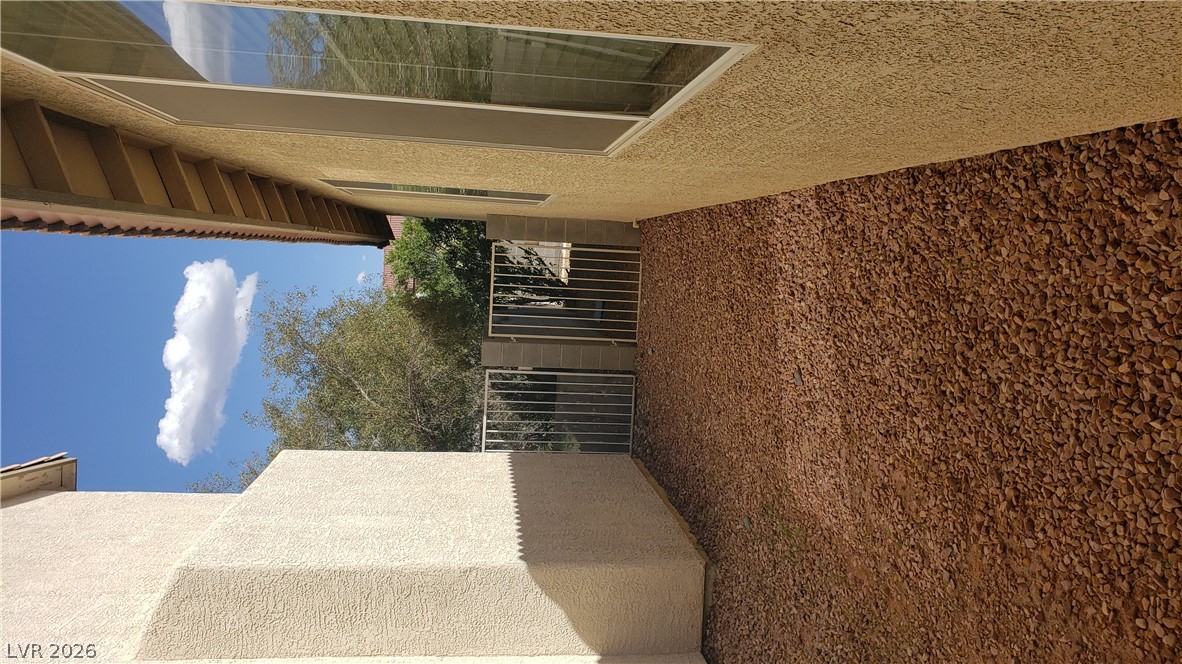 9112 Manalang Road Las Vegas, NV 89123 - Photo 8 of 50 Secure gated access connects the residence to the outdoor space, with a low-maintenance gravel ground cover.