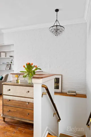 a white building with a fireplace and potted plant