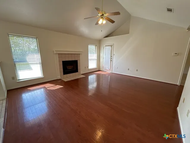 a view of a room with wooden floor and a fireplace
