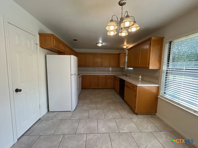 a kitchen with granite countertop cabinets and refrigerator