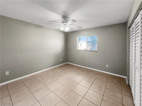 an empty room with windows and fan