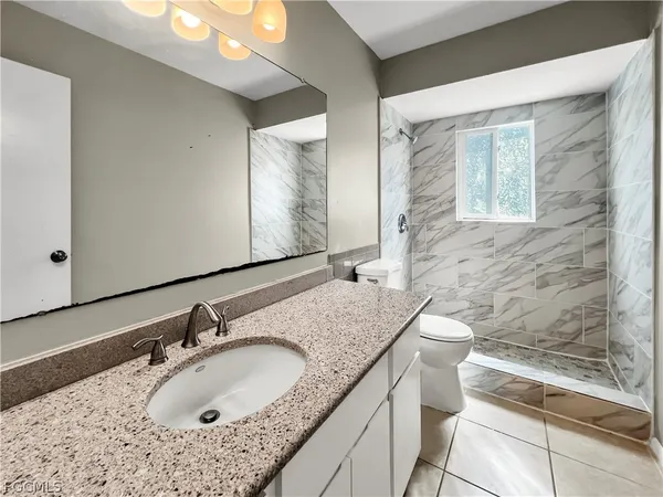 a bathroom with a granite countertop sink and a bathtub