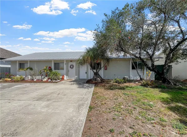 a view of a house with backyard and a tree