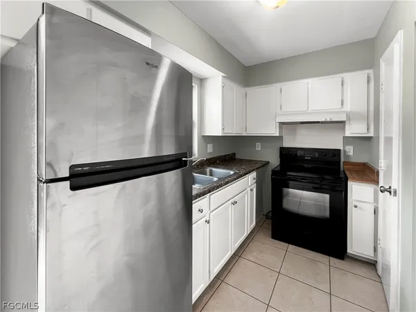 a kitchen with granite countertop a refrigerator and a stove