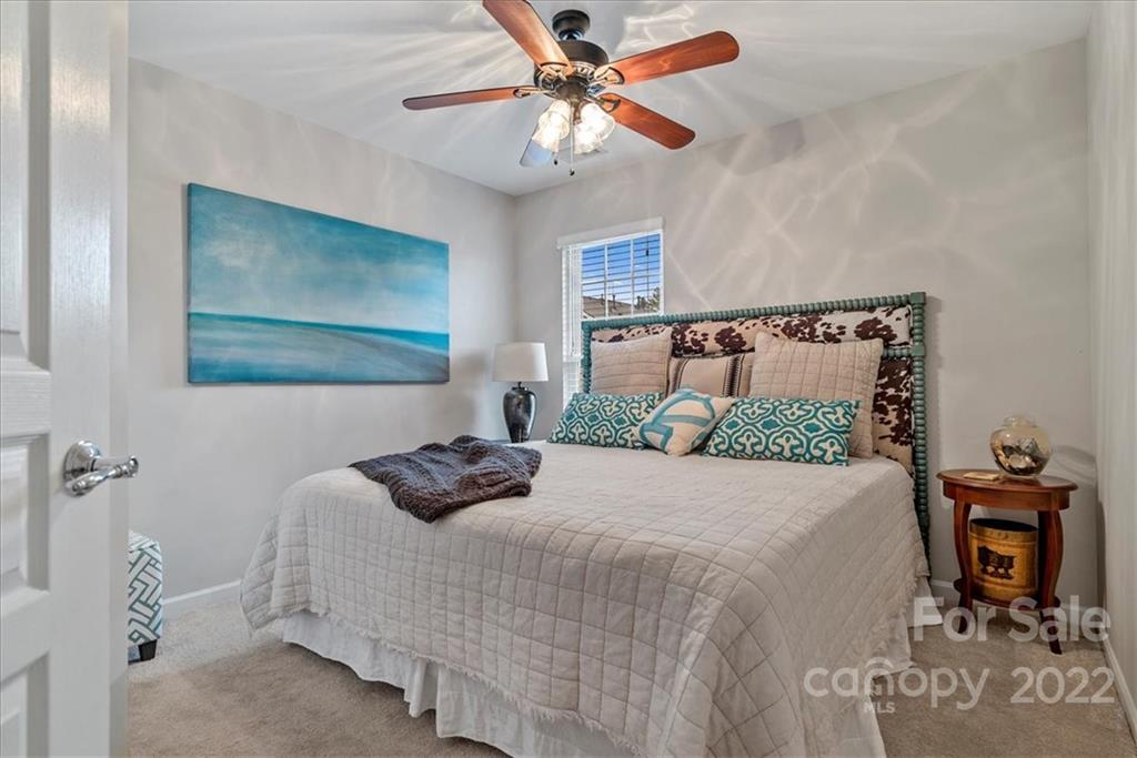 647 6th Baxter Crossing Fort Mill, SC 29708 - Photo 22 of 34 a bedroom with a bed and a chandelier