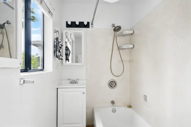 a bathroom with a white bath tub sitting next to a window
