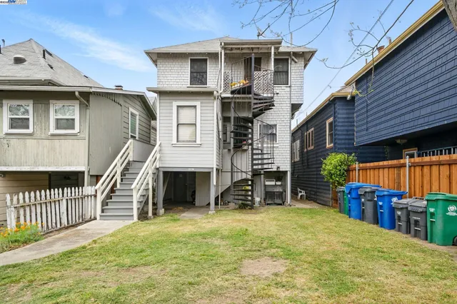a view of a house with wooden deck and furniture