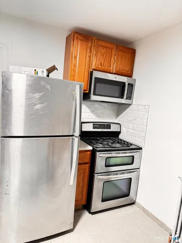 a white refrigerator freezer and a stove sitting inside of a kitchen