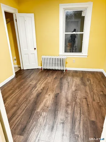 a view of a room with wooden floor and a window