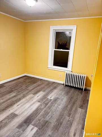 a view of a room with wooden floor and a floor to ceiling window