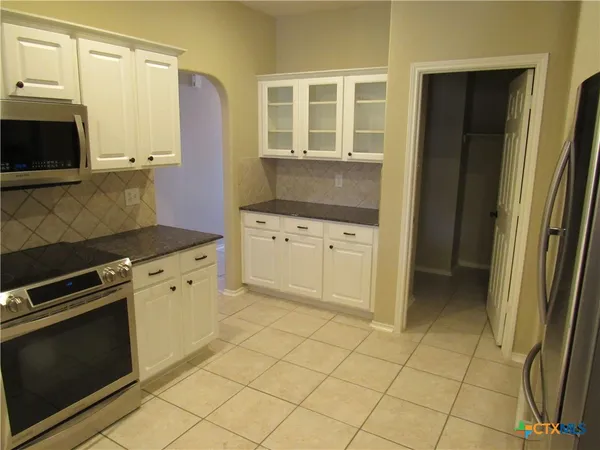 a kitchen with granite countertop a stove a microwave and a sink