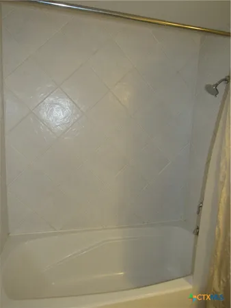 a bathroom with a shower and a bath tub