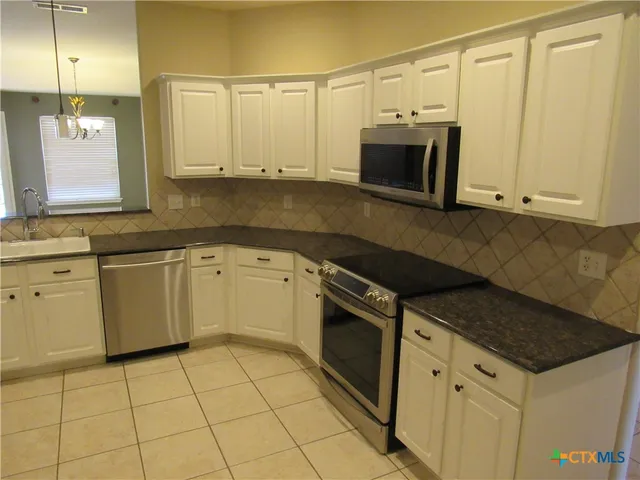 a kitchen with stainless steel appliances a stove a microwave and a sink