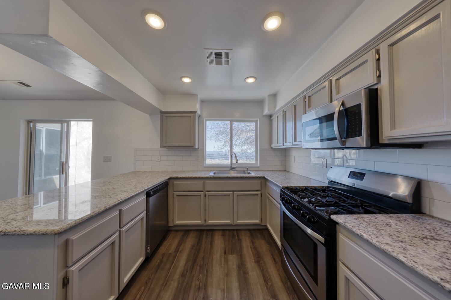26801 Cabriolet Court Tehachapi, CA 93561 - Photo 13 of 60 a kitchen with stainless steel appliances granite countertop a stove and a sink