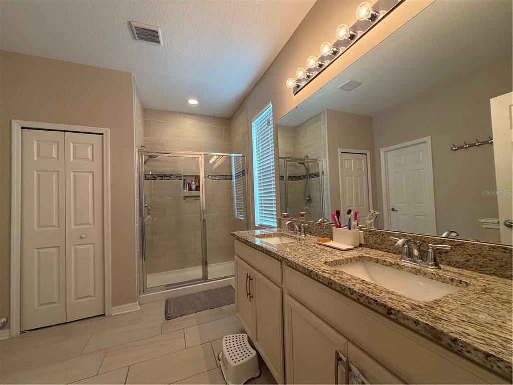 1834 Castleton Drive St. Cloud, FL 34771 - Photo 16 of 33 a bathroom with a granite countertop double vanity sink and mirror