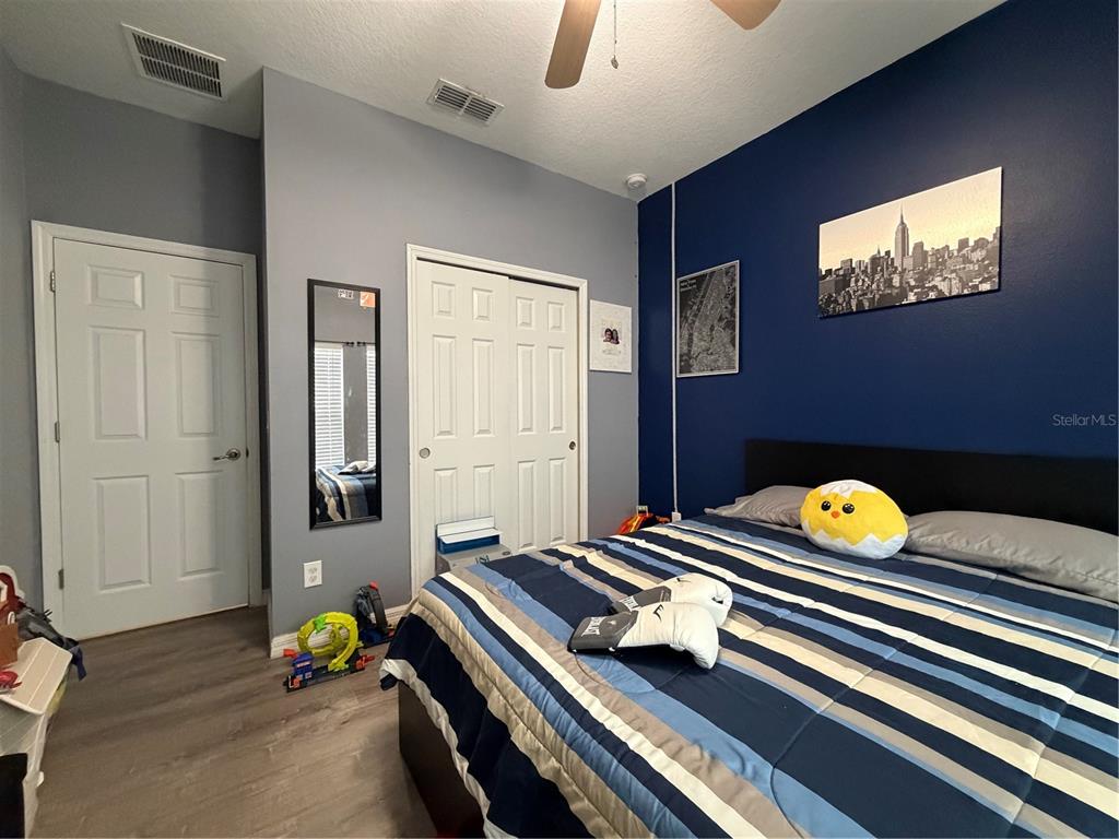 1834 Castleton Drive St. Cloud, FL 34771 - Photo 19 of 33 a bedroom with bed and paintings on the wall