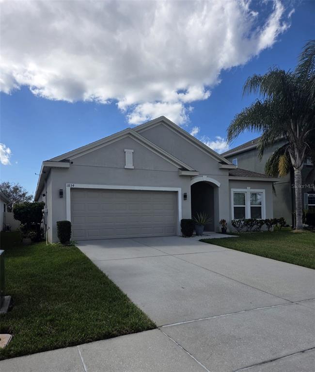 1834 Castleton Drive St. Cloud, FL 34771 - Photo 2 of 33 a front view of a house with a garden and trees