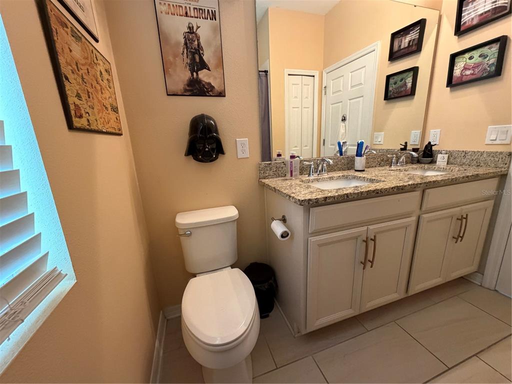 1834 Castleton Drive St. Cloud, FL 34771 - Photo 22 of 33 a bathroom with a granite countertop toilet sink and mirror