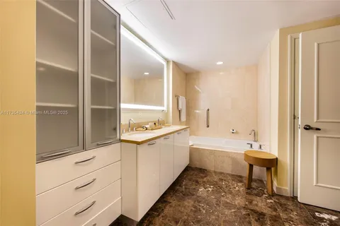 a large bathroom with a double vanity sink a mirror and a bathtub