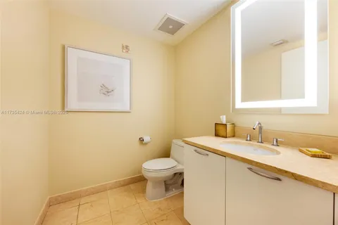 a bathroom with a granite countertop sink mirror and toilet