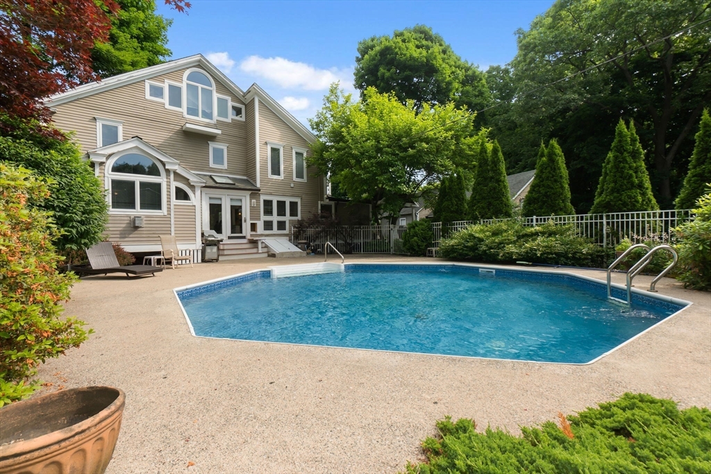a view of a house with pool plants and trees