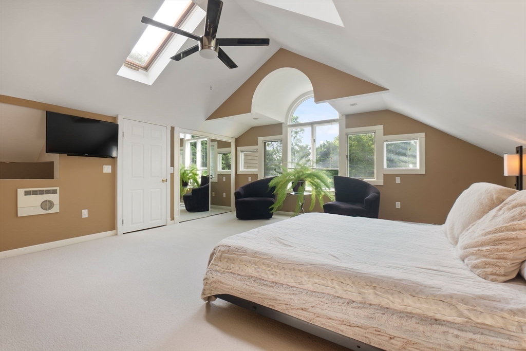 11 Bartlett Place Amesbury, MA 01913 - Photo 21 of 41 a bedroom with a bed a flat screen tv and a chandelier