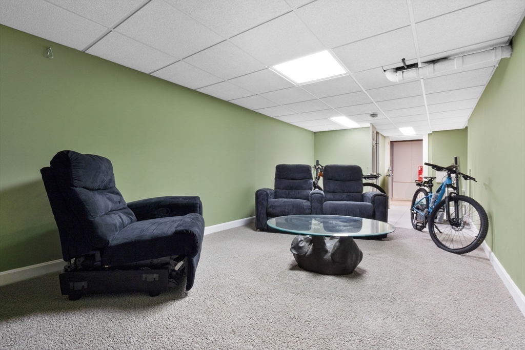 11 Bartlett Place Amesbury, MA 01913 - Photo 35 of 41 a living room with furniture a bike and a window