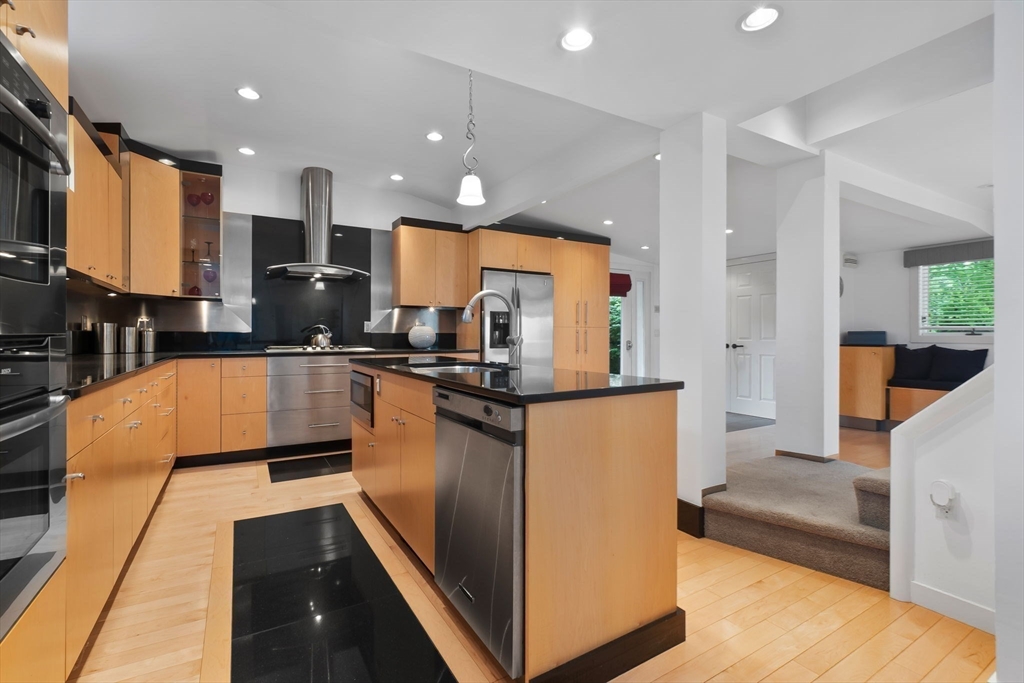 11 Bartlett Place Amesbury, MA 01913 - Photo 7 of 41 a large kitchen with stainless steel appliances kitchen island granite countertop a large counter top cabinets and a view of living room