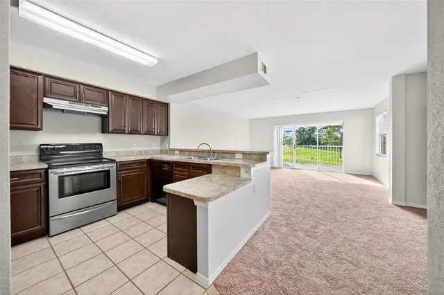 a view of a big room with windows and chandelier fan
