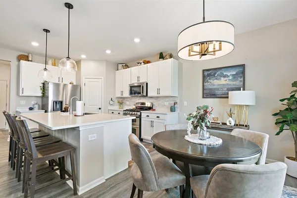 a kitchen with kitchen island a dining table and chairs