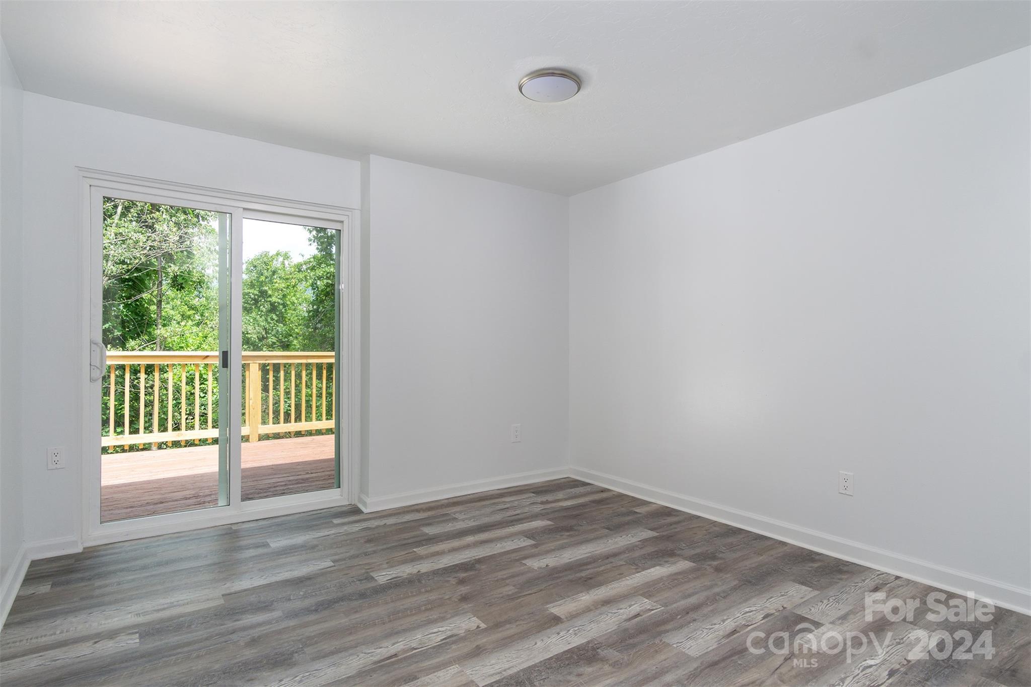 468 Deer Park Lake Road Spruce Pine, NC 28777 - Photo 12 of 46 a view of empty room with wooden floor and fan