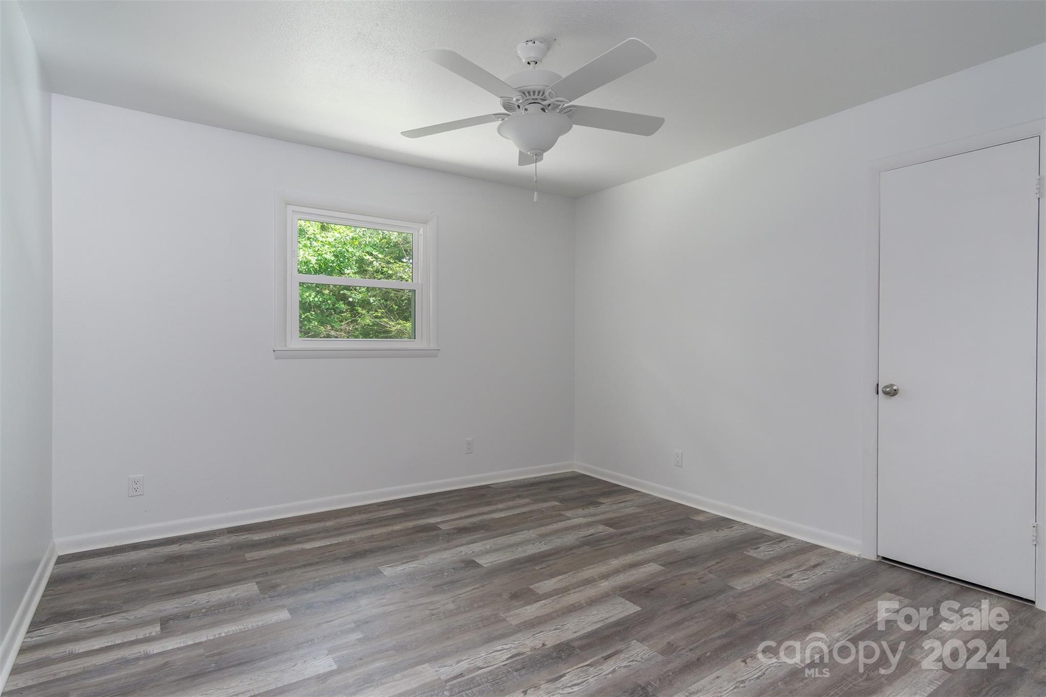 468 Deer Park Lake Road Spruce Pine, NC 28777 - Photo 36 of 46 an empty room with a window and a ceiling fan