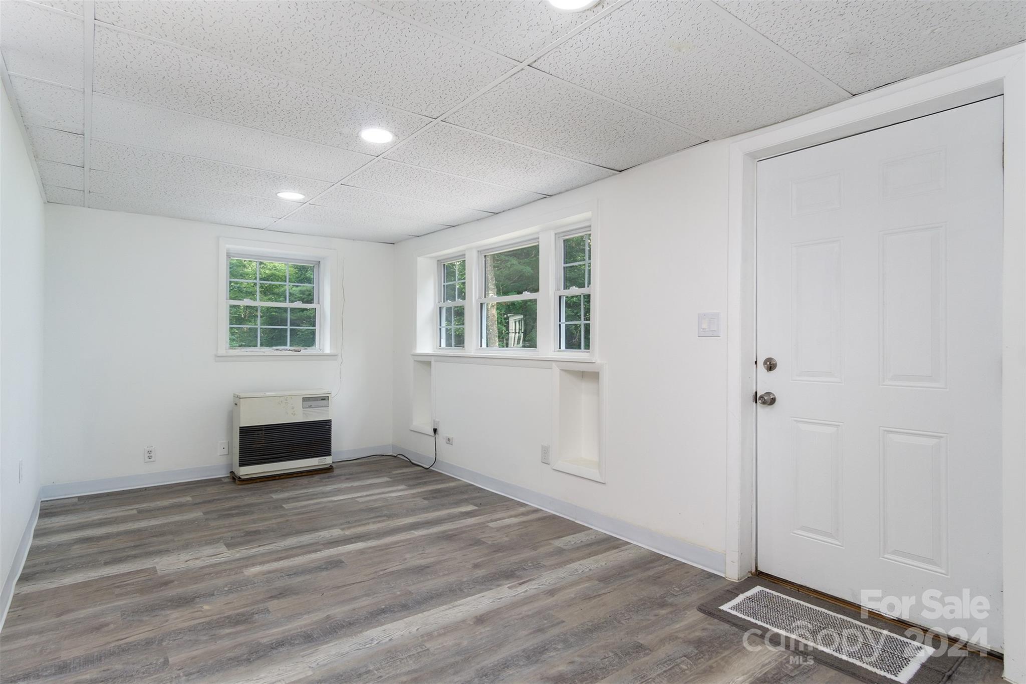 468 Deer Park Lake Road Spruce Pine, NC 28777 - Photo 38 of 46 an empty room with wooden floor cabinet and windows