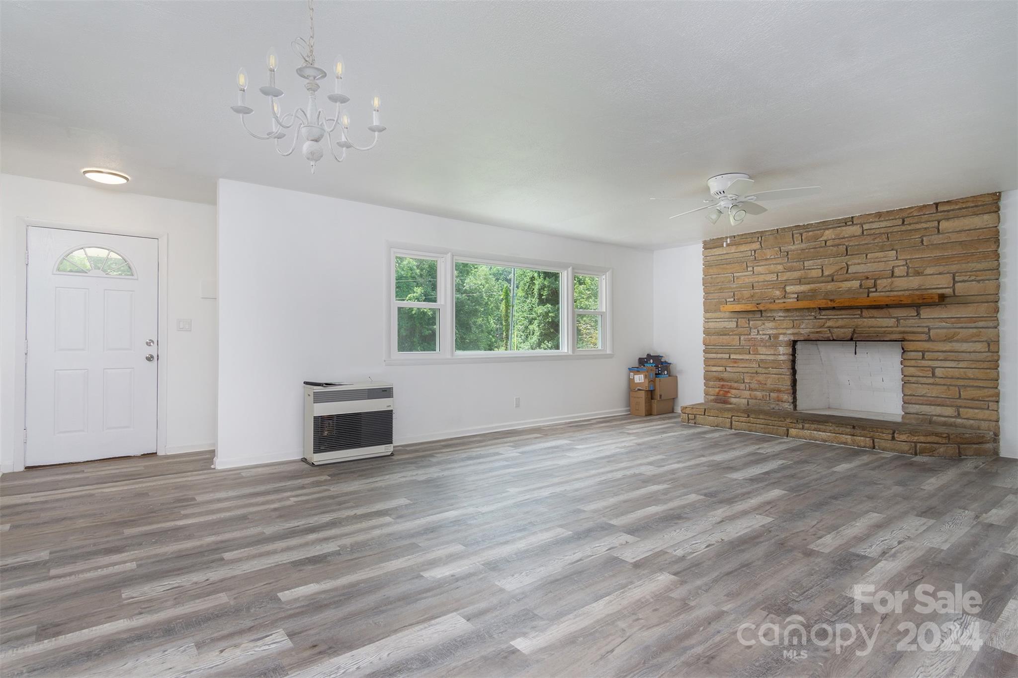 468 Deer Park Lake Road Spruce Pine, NC 28777 - Photo 9 of 46 an empty room with windows and fireplace