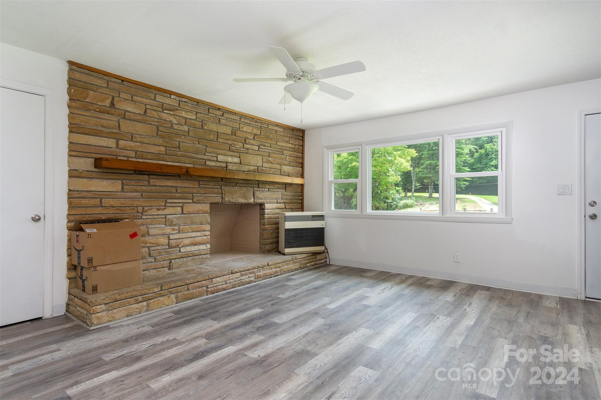 468 Deer Park Lake Road Spruce Pine, NC 28777 - Photo 10 of 46 a view of an empty room with a fireplace and a window