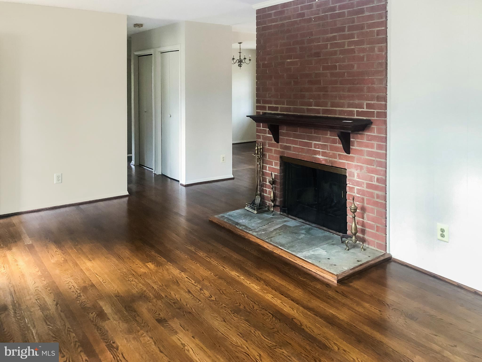 7202 Catlett Street Springfield, VA 22151 - Photo 6 of 28 an empty room with wooden floor fireplace and windows