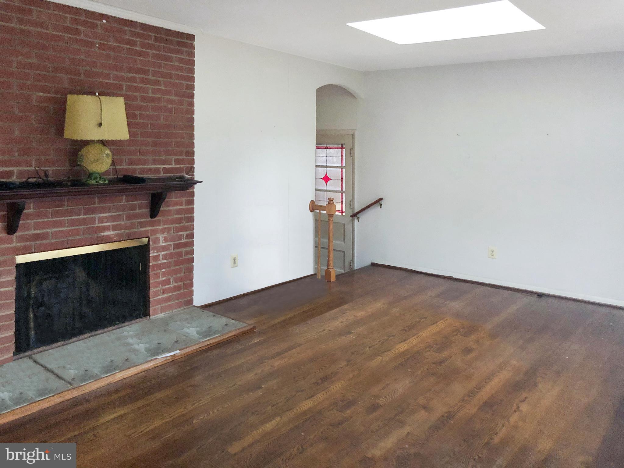 7202 Catlett Street Springfield, VA 22151 - Photo 8 of 28 a view of empty room with wooden floor and fireplace