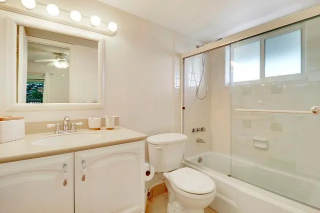 a bathroom with a granite countertop toilet sink and a mirror
