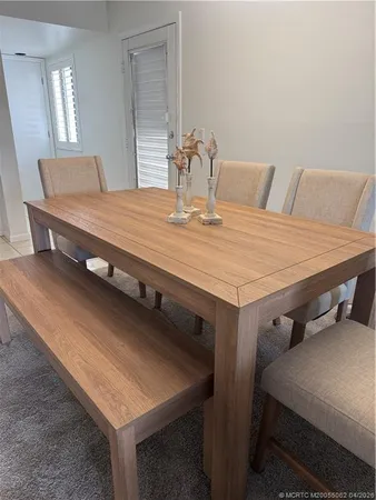 a dining room with a table chairs and kitchen view