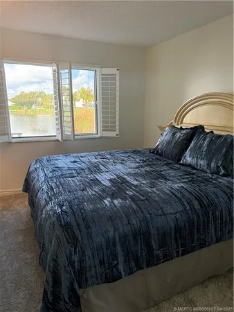 a bed sitting in a bedroom next to a window