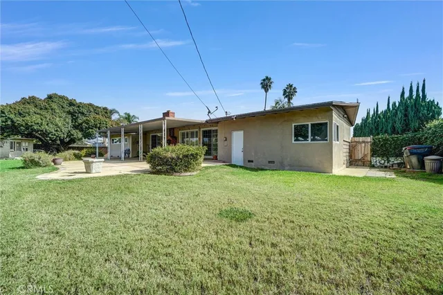 a view of a house with backyard and sitting area