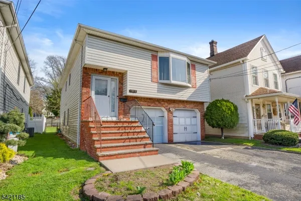 a front view of a house with a garden and plants