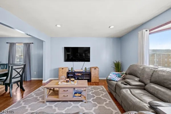 a view of a dining room with furniture a chandelier and wooden floor
